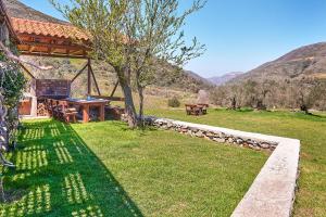 une table de pique-nique dans un champ avec des montagnes en arrière-plan dans l'établissement Authentic Cottage in a heaven of natural Beauty, à La Canée