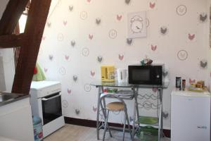 a kitchen with a counter with a microwave and a table at Suite dans les dépendances du Château in Agonges