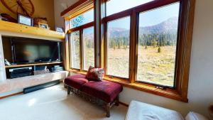 a living room with a large window and a tv at Snowcreek #760 condo in Mammoth Lakes