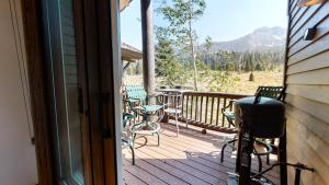 an open door to a deck with chairs and a grill at Snowcreek #760 condo in Mammoth Lakes