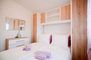 a bedroom with a bed with two purple towels on it at Holiday Home Sunset in Zadar +18 photos