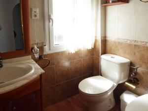 a bathroom with a toilet and a sink and a window at Vivienda rural casa manoli 