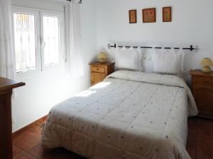 a bedroom with a bed with a white comforter at Vivienda rural casa manoli 