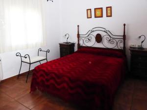 a bedroom with a red bed and a chair at Vivienda rural casa manoli 