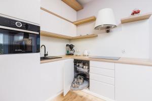 a kitchen with white cabinets and a sink at DreamView Premium Apartment Wisła Kamienna by Renters in Wisła