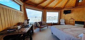 um quarto com uma secretária e uma cama num quarto em Cabañas y Casa Kauken em Puerto Natales