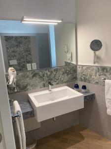 ein Badezimmer mit einem weißen Waschbecken und einem Spiegel in der Unterkunft Porto di mare b&b in Giovinazzo