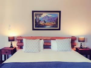 a bedroom with a large bed with two night stands at Winelands Villa Guesthouse and Cottages in Somerset West