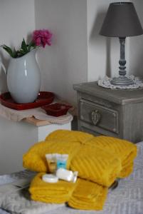Una cama con una manta amarilla y una mesa con un jarrón en B&B Il moro selvatico, en Poviglio