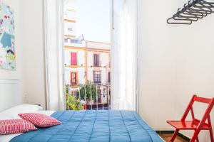 Un dormitorio con una cama azul y una ventana en Onefam Centro, en Sevilla