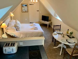 a bedroom with a large bed and a table and a tableablish at Fox Inn in Darsham