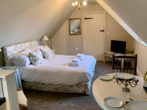 a bedroom with a bed and a table and a tv at Fox Inn in Darsham