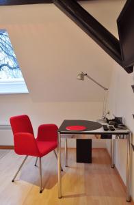 an attic office with a desk and a red chair at Suite „Hannover“ - modernes Apartment in Fachwerkhaus in Hannover