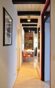 a hallway with a table and a red chair at Suite „Hannover“ - modernes Apartment in Fachwerkhaus in Hannover