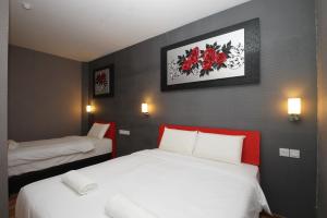 Habitación de hotel con 2 camas con detalles en rojo en Ipoh Boutique Hotel, en Ipoh