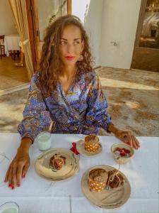 a woman sitting at a table with plates of food at Masseria Spina Resort in Monopoli