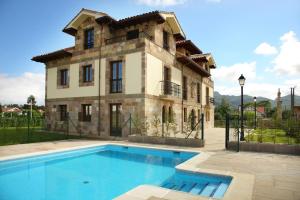 una casa grande con piscina frente a ella en Apartamento Casona de la Viesca, en Liendo