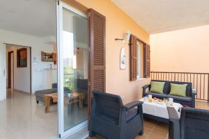 a living room with two chairs and a table and a couch at Tamarels beach apartment in Pollensa in Pollença