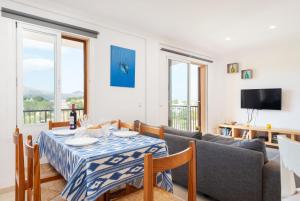 a living room with a table and a couch at Tamarels beach apartment in Pollensa in Pollença