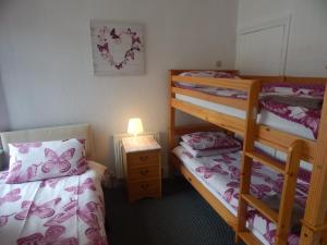 a bedroom with two bunk beds and a lamp at Llanryan Guest House in Blackpool