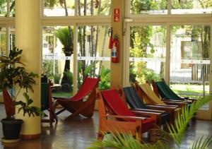 a group of chairs in a room with windows at Hotel Cataguases in Cataguases