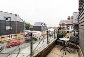 a balcony with a small red car on a street at 1-bedroom apartment with balcony, Hoddesdon in Hoddesdon