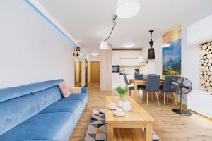 sala de estar con sofá azul y mesa en DreamView Premium Apartment Wisła Kamienna by Renters, en Wisła