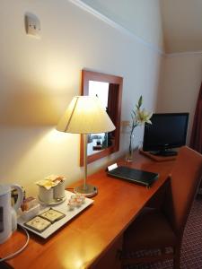 a desk with a lamp and a computer on it at The Tudor Hotel in Harrow