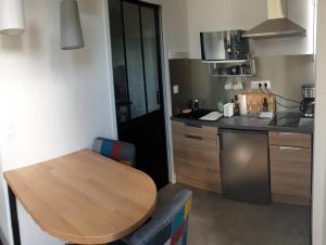 a kitchen with a wooden table and a kitchen with a counter at Le studio des talents au coeur de Chaumont in Chaumont