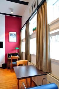 ハノーファーにあるSuite „Herrenhausen“ - stilvolles Apartment in Fachwerkhausの赤い壁のダイニングルーム(テーブル付)