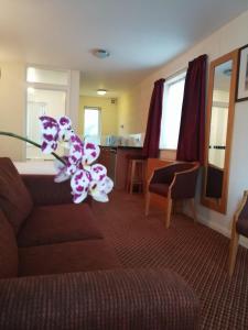 a living room with a couch and a flower at The Tudor Hotel in Harrow