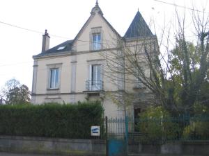 una casa blanca con una valla delante en Le studio des talents au coeur de Chaumont, en Chaumont