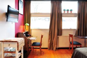 ハノーファーにあるSuite „Herrenhausen“ - stilvolles Apartment in Fachwerkhausのベッド1台、椅子2脚、デスクが備わる客室です。