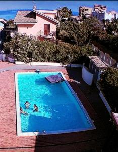 uma piscina com duas pessoas na água em Nuovo Apt in Villa full optional con piscina e veranda vista mare a 500 mt dalla spiaggia della Scala em Realmonte