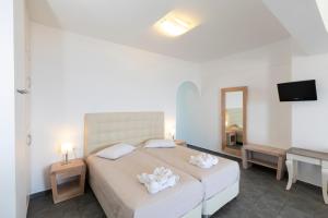ein Schlafzimmer mit einem großen Bett und einem TV in der Unterkunft Erato Apartments in Firostefani