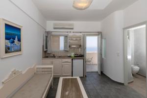 a white kitchen with a sink and a toilet at Erato Apartments in Firostefani