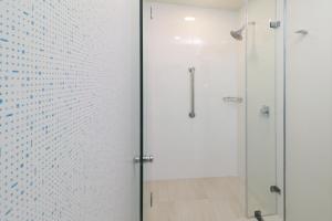 y baño con ducha y puerta de cristal. en Holiday Inn Express Guadalajara Iteso, an IHG Hotel, en Guadalajara