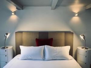 - une chambre avec un lit doté d'un oreiller rouge et de deux lampes dans l'établissement CITY CENTER Apartments, à Prague