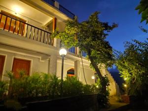 a white house with a street light in front of it at Enchanted Hills Farmstay in Mukteswar