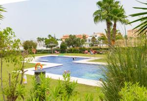 una piscina en un parque con gente dentro en Flamingo Golf B, en Sanlúcar de Barrameda