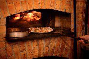 a brick oven with a pizza in it at Batey Hotel Boutique in Boca Chica