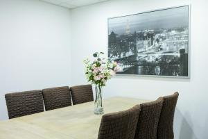 a vase of flowers on a table with chairs at Apartment "Paris" in Korschenbroich