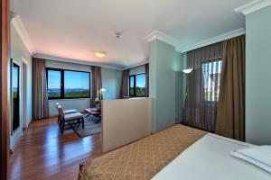 a bedroom with a bed and a desk and windows at Agora Life Hotel - Special Class in Istanbul