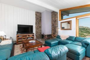 a living room with a blue couch and a television at Shadowbrook 302 in Snowmass Village
