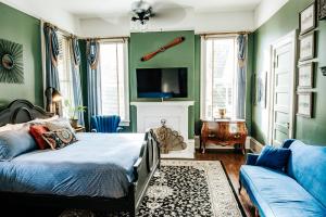 ein Schlafzimmer mit grünen Wänden, einem Bett und einem Sofa in der Unterkunft Heritage House Bed & Breakfast - Boutique Adults-Only Inn in Opelika