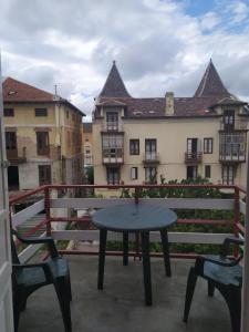 a table and chairs on a balcony with a building at Pensión Luisito in Santander
