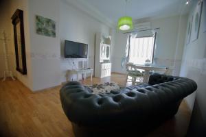 sala de estar con sofá de cuero y mesa en casa di mimma appartamento 98 mq, en Reggio Calabria