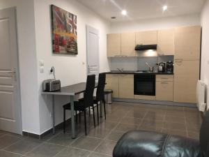 ラ・トゥール・デュ・パンにあるAppartement la Gareのテーブルと椅子のあるキッチンとリビングルーム