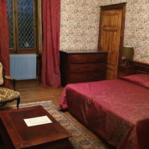 a bedroom with a bed and a table and a chair at Château d'Island Vézelay in Pontaubert