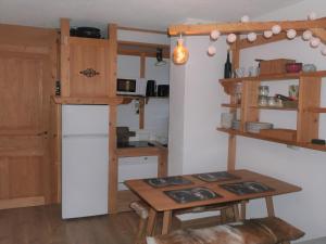 eine kleine Küche mit einem Tisch und einem Kühlschrank in der Unterkunft La Belle Etoile in Manigod